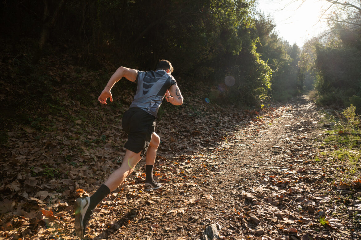 Male athlete running cross-country in the early morning